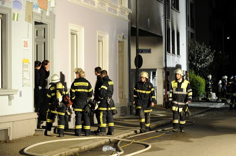 Hasi�i p�ed vchodem do domu, ve kterém N�mka odpálila nálo�